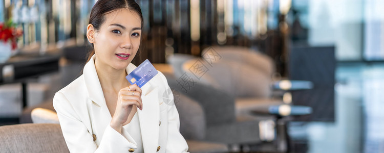 网络无现金Banner网页或封面模板利用信卡在现代大厅或工作空间在线购物的亚洲肖像妇女使用信卡技术钱财包和网上付款概念信用卡模拟图片