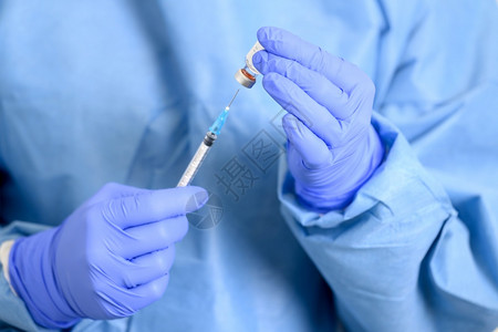手拿针筒注射疫苗的医生特写图片