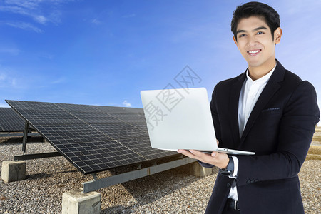 技术安装控制板从事膝上型计算机工作的商人或程师与蓝色天空背景替代清洁绿色能源概念的太阳电池板一起工作图片