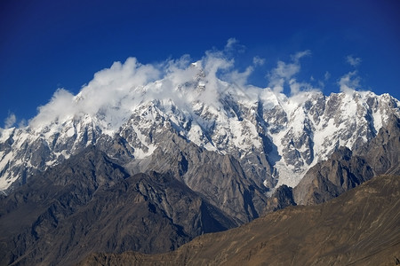 蓝色的BaturaMuztagh云后面的乌尔塔萨山峰卡拉科姆山脉位于巴基斯坦吉尔特俾提斯坦Hunza山谷生态在后面图片