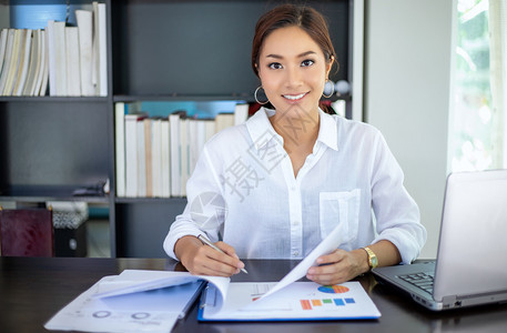 笔记本电脑亚洲美丽的商业妇女检查文件并使用笔记本在家中工作以达到社会距离和自我责任概念亚洲美丽的商业女人联系屋图片