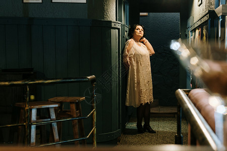复古的在老餐馆里身着衣服站在墙边的女人浅露深处的田地夜生活图片
