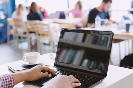 沟通教育商人在咖啡店用笔记本电脑工作在咖啡店白色的图片
