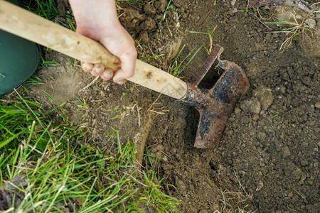 场地白种人污垢在田野或花园里挖一个洞白天在农场顶楼的视野下工作每天在田地或花园里挖一个洞图片