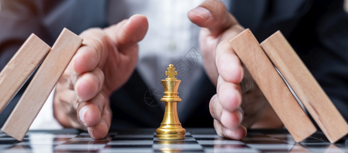 有效的商业人亲手保护象棋王人物和阻止木块或多米诺斯企业风险管理解决方案经济倒退保险战略和中断概念等公司活动组织CEF经济的背景图片
