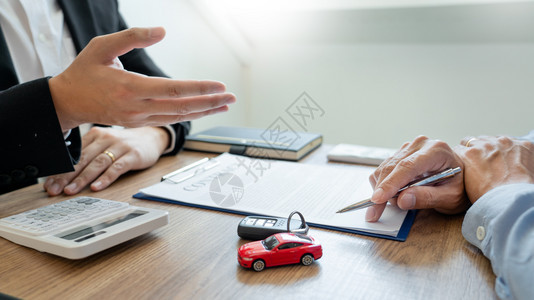 金融的顾客贷款向户所有权和持汽车钥匙的销售员出示运输合同表格的代理经纪人持有文件并附汽车钥匙图片