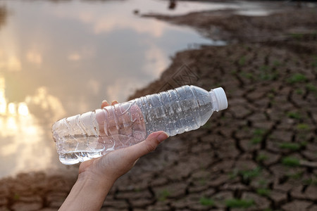 保持内脏近身女手握着裂土背景的透明塑料瓶这些废物来自城市和工业区无法摆脱得到图片
