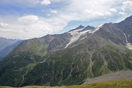 落基山脉全景范围在蓝色天空和白云下的高加索山脉夏季在俄罗斯联邦奥古特山的北高加索地貌下进行夏日活动图片