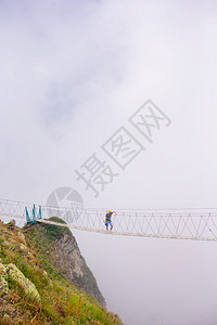 户外位于俄罗斯莎胡托尔山顶的绳桥俄罗斯青年在一座吊桥上横跨山脉深渊俄罗斯莎胡托尔山顶的绳桥游客蓝色图片