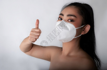 口罩筛选外科医生身戴用面罩的亚洲年轻女近身穿上医疗面具N95以保护免受空气呼吸道疾病如灰色背景的流感共食19PM25粉尘和烟雾安图片