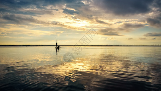 冷静的美丽自然景观天空的金色阳光一只小船上的双影渔民利用网在清晨使用渔网日出时在泰国费特隆松赫拉湖SongkhlaLake上16图片