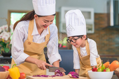 配料蔬菜紫色的快乐亚洲美女和可爱的小男孩带着眼镜准备在家中厨房做饭人们的生活方式和家庭自制食物原料概念两个泰国人的生活两个泰国人图片
