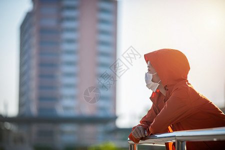 身体空气亚裔年轻健身运动女在赛跑她戴着面具保护城市灰尘与污染在城市中使用防尘和污工具日落图片