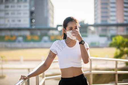 跑步成人夏天亚裔年轻健身运动女在赛跑她戴着面具保护城市灰尘与污染在城市中使用防尘和污工具图片