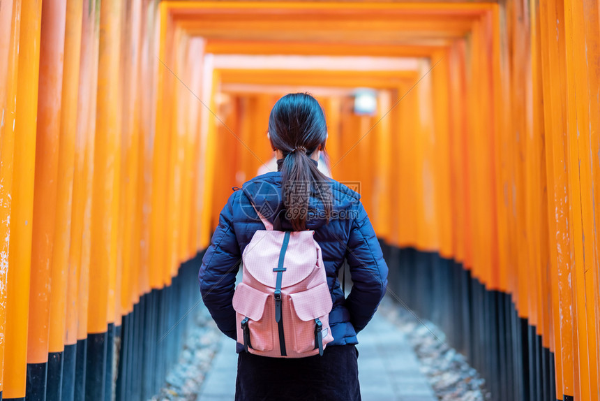 年轻女在日本亚洲京都旅游观光景点很受欢迎在日本京都游览观光景点时看着充满生机勃的橙色托里城大门程碑伏见亚洲人年轻的图片