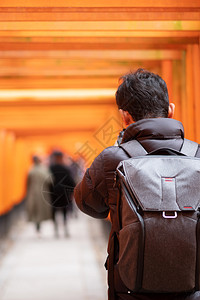 木头年轻男子在日本京都旅游观光景点很受欢迎日本亚洲旅游概念亦然在日本京都的观光景点中身穿橙色托里城门标志地处充满活力热门风气勃吸图片