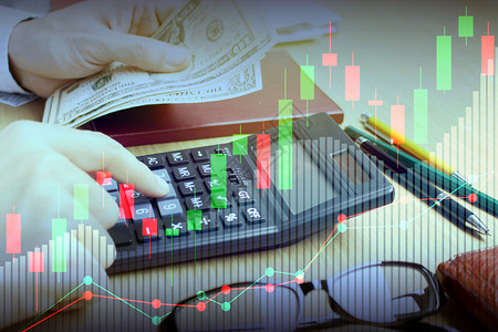 手机双重接触用计算器和股票市场或金融投资概念财务图表的双重情况用于金融投资概念贸易药片图片