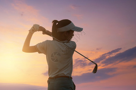 户外帽亚洲女青年运动员亚洲高尔夫球手在课场上中弹日落天空暗夜背景演练和健康概念Golf练习成为职业高尔夫球手图片