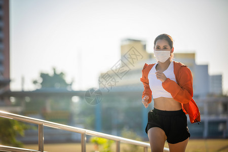 户外戴着口罩跑步的年轻女子图片