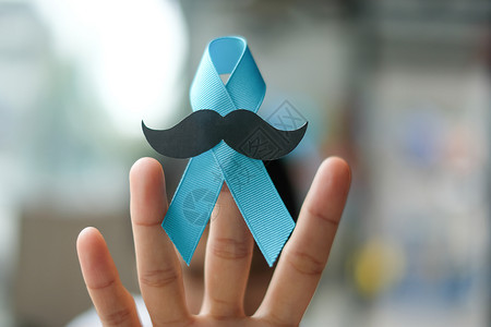 关心前列腺癌症意识Wonan手握着轻蓝丝带胡子的小以支持人们生活和患病者的健康护理和世界癌症日概念理发师慈善机构图片