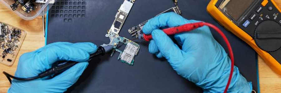 电话修理概念一名年轻的电气技术员使用一个计量电子设备路流的仪表测量维护硬件服务图片
