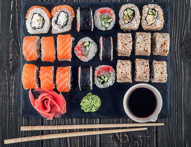 日本生鱼片亚洲各种寿司卷在板球上滚费城加利福尼亚州和洛罗斯配有黄瓜姜汁和豆酱图片