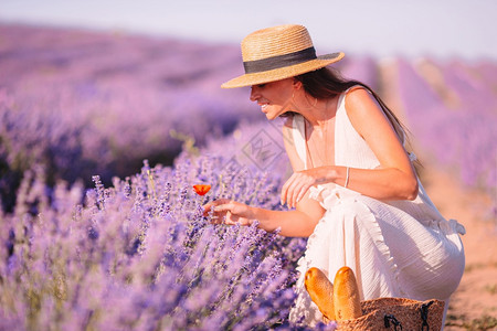 夏天紫花衣草地上美丽的年轻女在日落时紫花衣和白帽子下发现了一位红女郎紫色孩图片