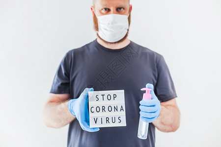 在科罗纳COVID19传染病流行期间身戴乳胶医用手套和保护面罩的人手中Coronna健康护理艾滋预防安全的木板图片