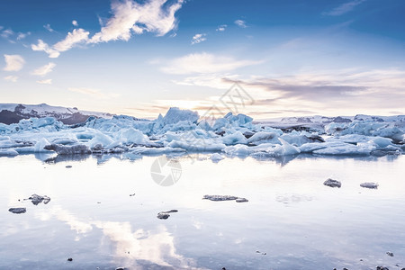 约古沙龙融化冰岛的Jokulsarlon冰川环礁湖的山景象日落时有选择地聚焦酷凉古代风格效应图片