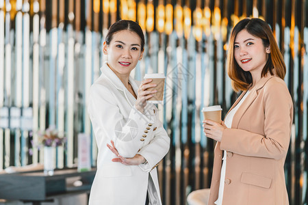 杯子亚洲人在现代办公室或合用空间的咖啡休息期有两名亚洲女商人在咖啡休息下班后放松和谈话商业人员伙伴关系概念时发言种族图片
