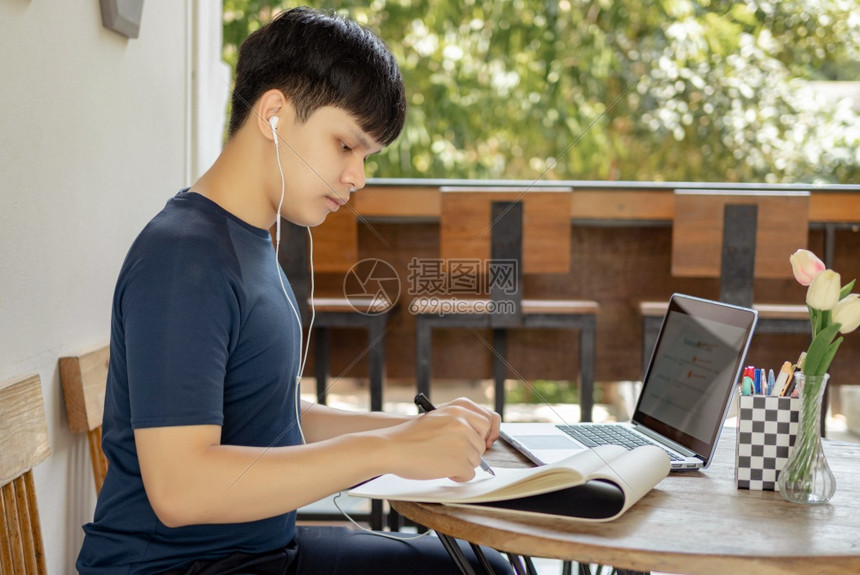 独自对着笔记本电脑学习的男生图片