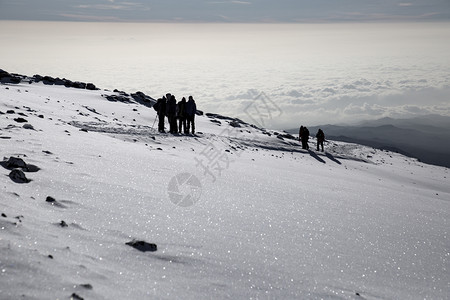 登山者小组在乞力马扎罗高峰会到达目的地全景大约风暴图片