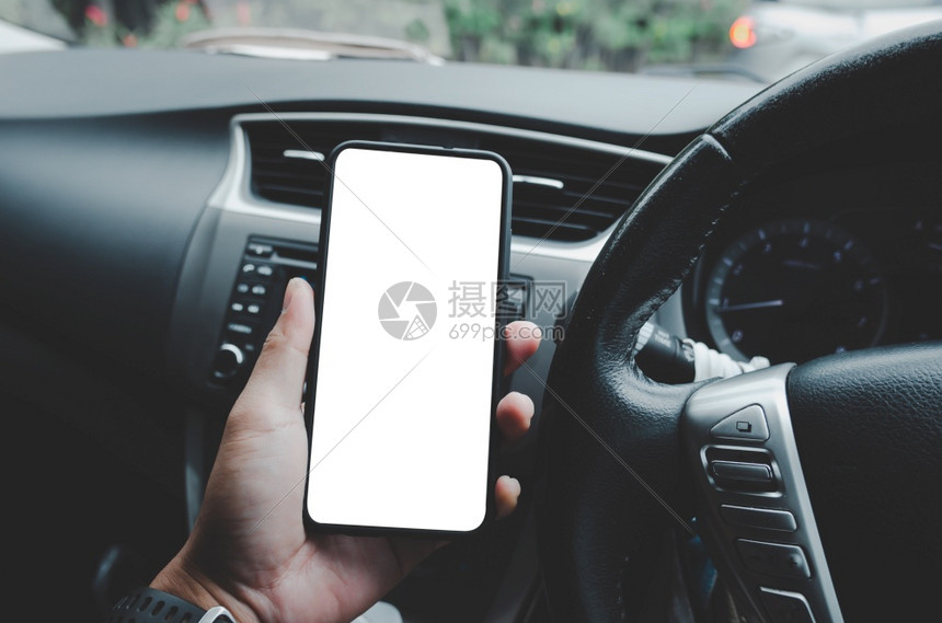 语气白色的小工具驾驶员在一辆装有白色空屏幕的模拟汽车上持有移动电话一个人在看智能手机时正在寻找全球定位系统导航器信息校对路径音调图片