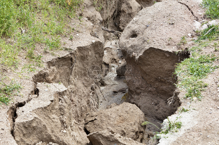 山路大雨后土壤侵蚀在绿种植被下大雨后山区道路上的土壤被毁坏山道上大雨后土壤流失水分生态风景图片