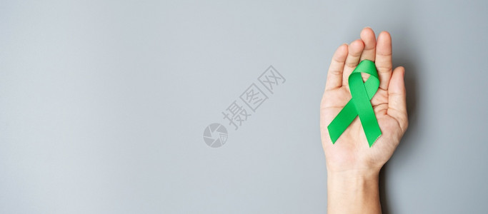 男子持有绿色丝带以支持生活和患病者ListerGallbladdersbile管道肾癌和淋巴瘤认识月概念肝保持器官背景图片