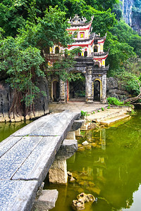 修道院佛教徒越南旅游目的地NinhBinh古代BichDong塔综合建筑的门入口露天公园外风景湖边和石桥复杂的图片