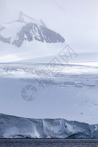 冷若冰霜川边缘雪笼罩的山上冰雪沉落在雾中光线照亮图片