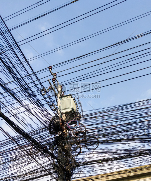 通信电缆互联网话等都缠在变压器装置下的电线杆上这是靠近泰国商业区的一个城市地Thai的变压器装置网络基础设施行业图片