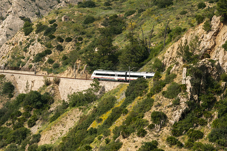 美丽多岩石的爬坡道火车穿过一个隧道横跨阿勒萨里安达卢西亚大山谷周围是丘图片