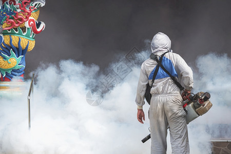 发烧健康在泰国Samutsakhon的神庙利用雾机喷洒化学品以消除蚊虫和防止登革热让身着防护服的室外保健工作者近视以消灭蚊虫并防图片