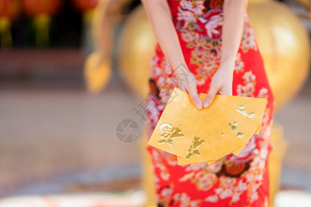身着青山传统红衣装饰手拿着黄信封的近身妇女在泰国中华神庙举办新年节庆日活动神社漂亮的奖金图片