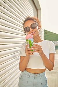 微笑穿着白色T恤衫和轻牛仔裤的年美籍非裔女孩在阳光日吃冰淇淋有选择地关注小重点领域甜的有趣图片