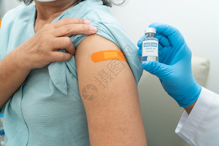 拿注射器护士为女病人接种预新冠疫苗背景