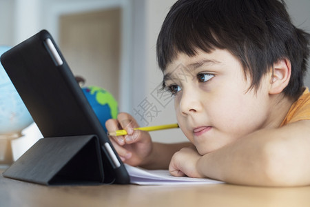 在家使用平板电脑学习的男孩图片