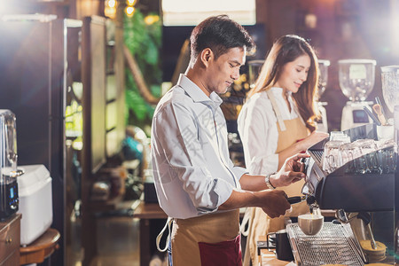 调酒师服务浇注亚洲酒吧准备咖啡加拿铁或卡布奇诺咖啡供店的顾客点菜制咖啡小商业主和咖啡店餐馆的开业概念以及图片