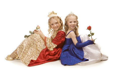 可爱的水平两个美丽笑着小女孩穿长金发的穿着公主服装坐在地板上两朵玫瑰红和蓝色帝国礼服连衣裙金子高清图片素材