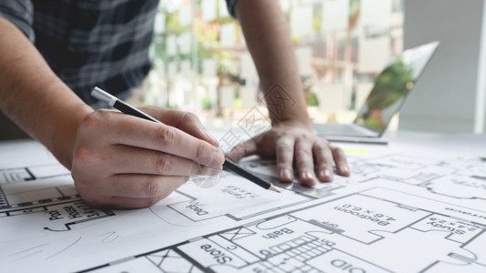 财产战略一名男建筑师测量和标志复杂蓝图大小比例的男建筑师起草图片