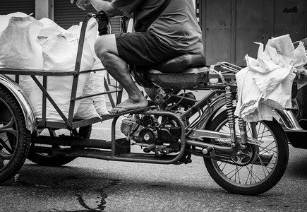 社会的公民贫穷老人驾驶摩托车将冰袋运到一家餐馆退休后老年人工作退休后从事工作退休时发生货币危机的概念福利和社会保障老龄化社会积极图片