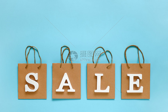 贸易市场文本销售从白色体积字母和蓝背景上的空白购物袋顶视图平躺模型概念折扣为您的文本设计广告或提供创意模板从白色体积字母和蓝背景图片