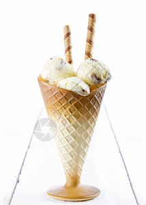 曲奇饼蛋糕甜点香草冰淇淋在白木背景的杯子上加面包饼图片
